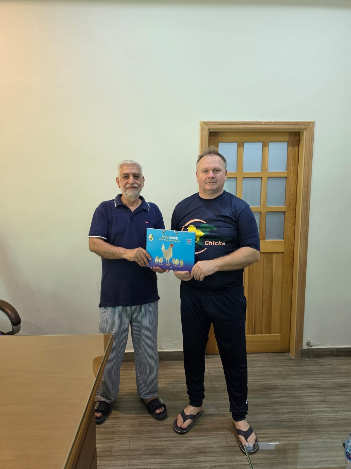 Team members holding H&N International management guide at the workshop